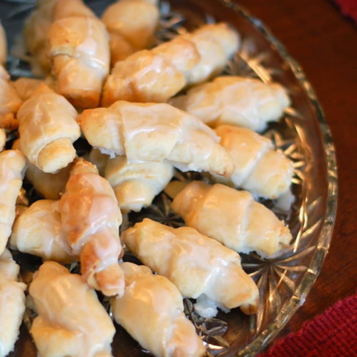 Butterhorn sweet rolls topped with a vanilla glaze on a glass dish.