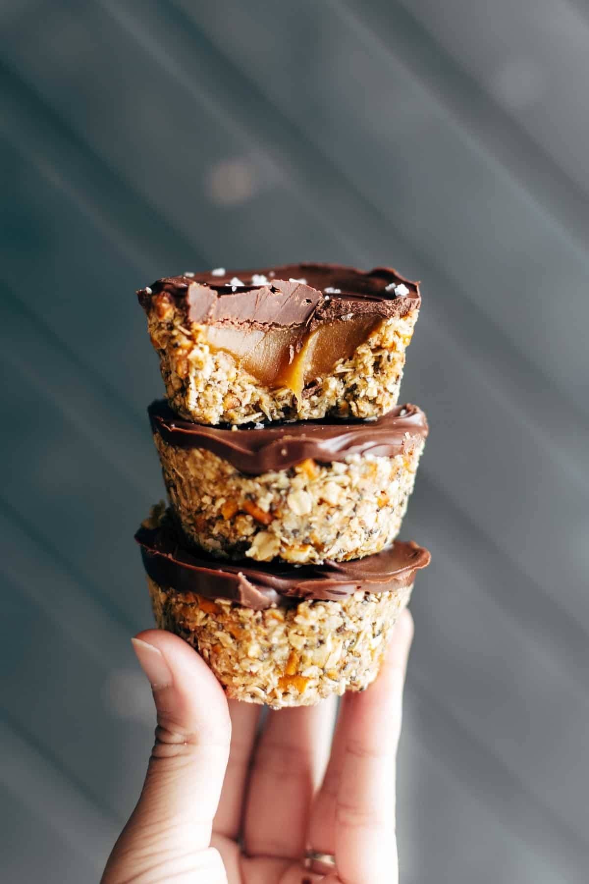 Hand holding three No-Bake Salted Caramel Cups.