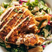 Salmon burgers on a bed of Mixed Greens in a bowl.