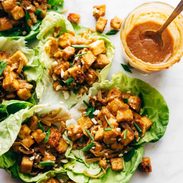 Firecracker Vegan Lettuce wraps in a row with hand.