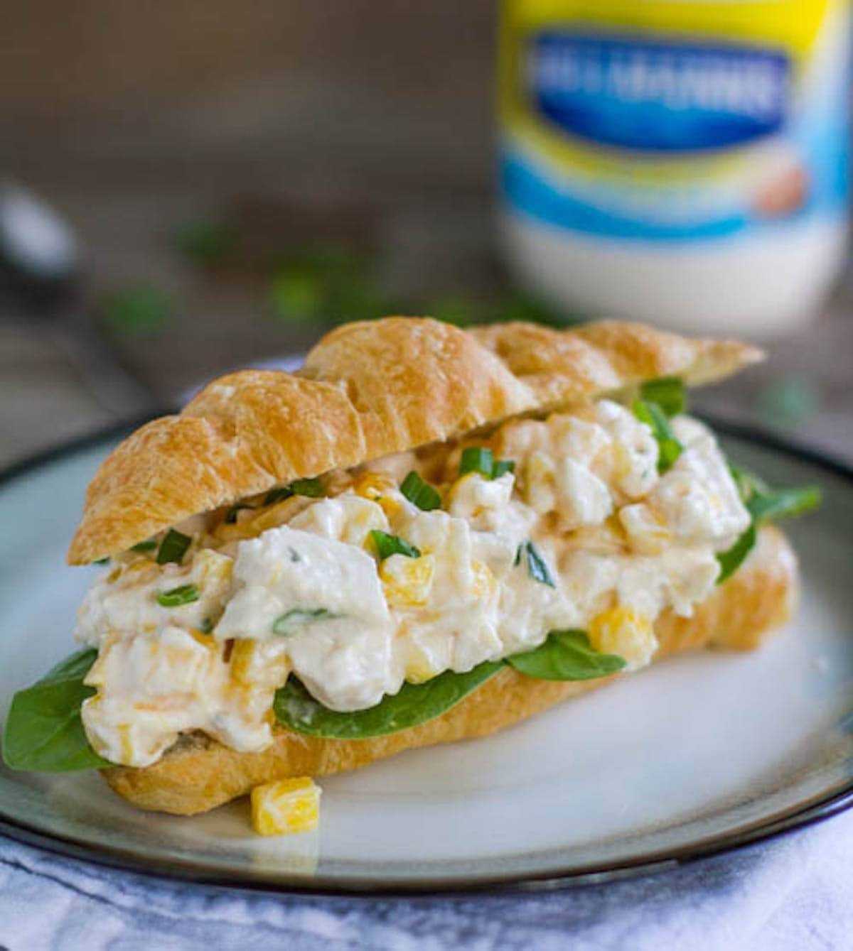 Mango chicken salad sandwich on a plate.