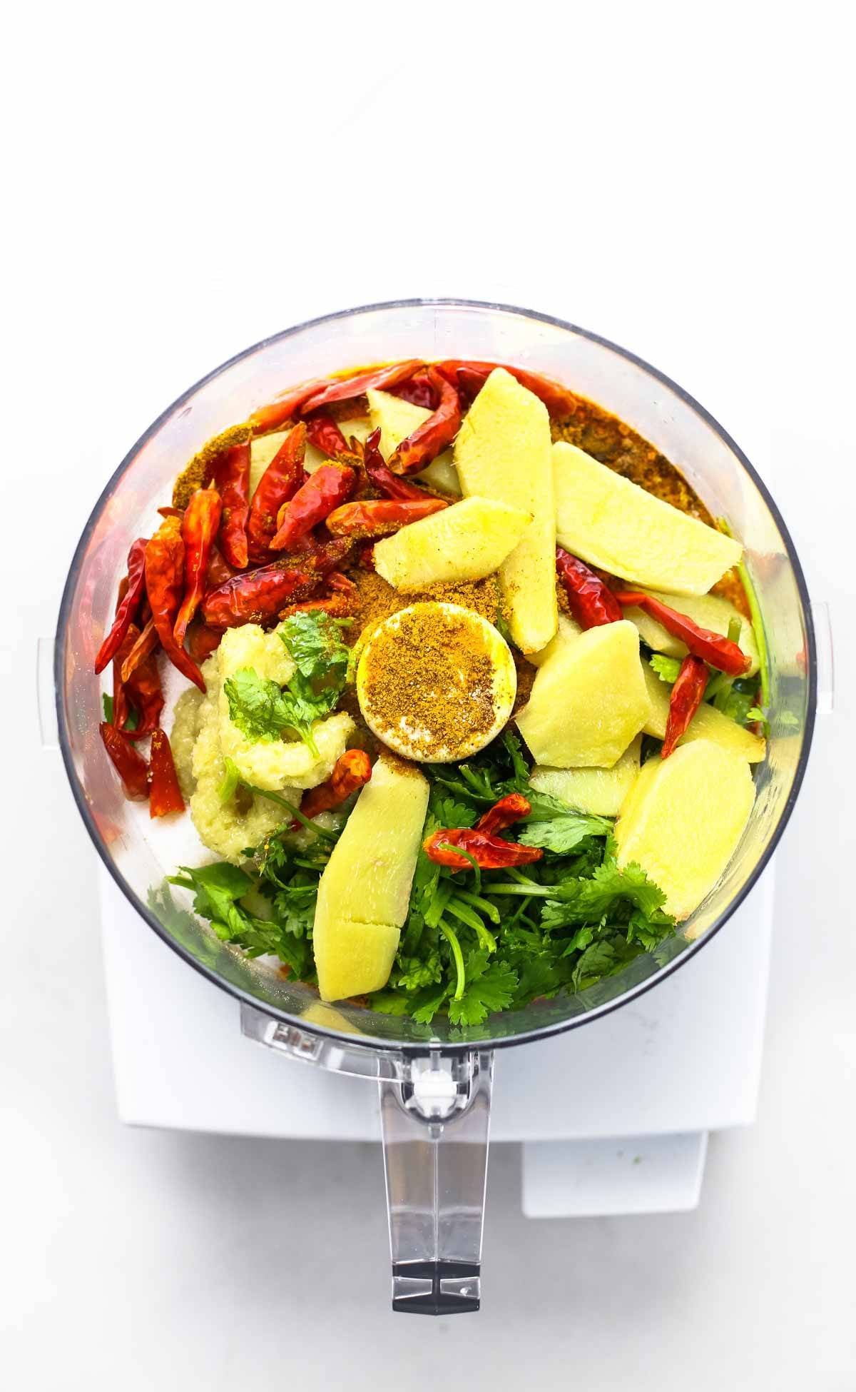 Ingredients for yellow curry paste in a food processor.